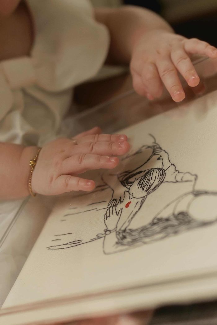 Mãos de um bebê sobre o desenho de uma peça